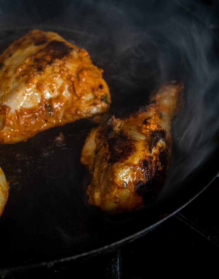 Chicken pieces being seared along with the tikka masala marinade.